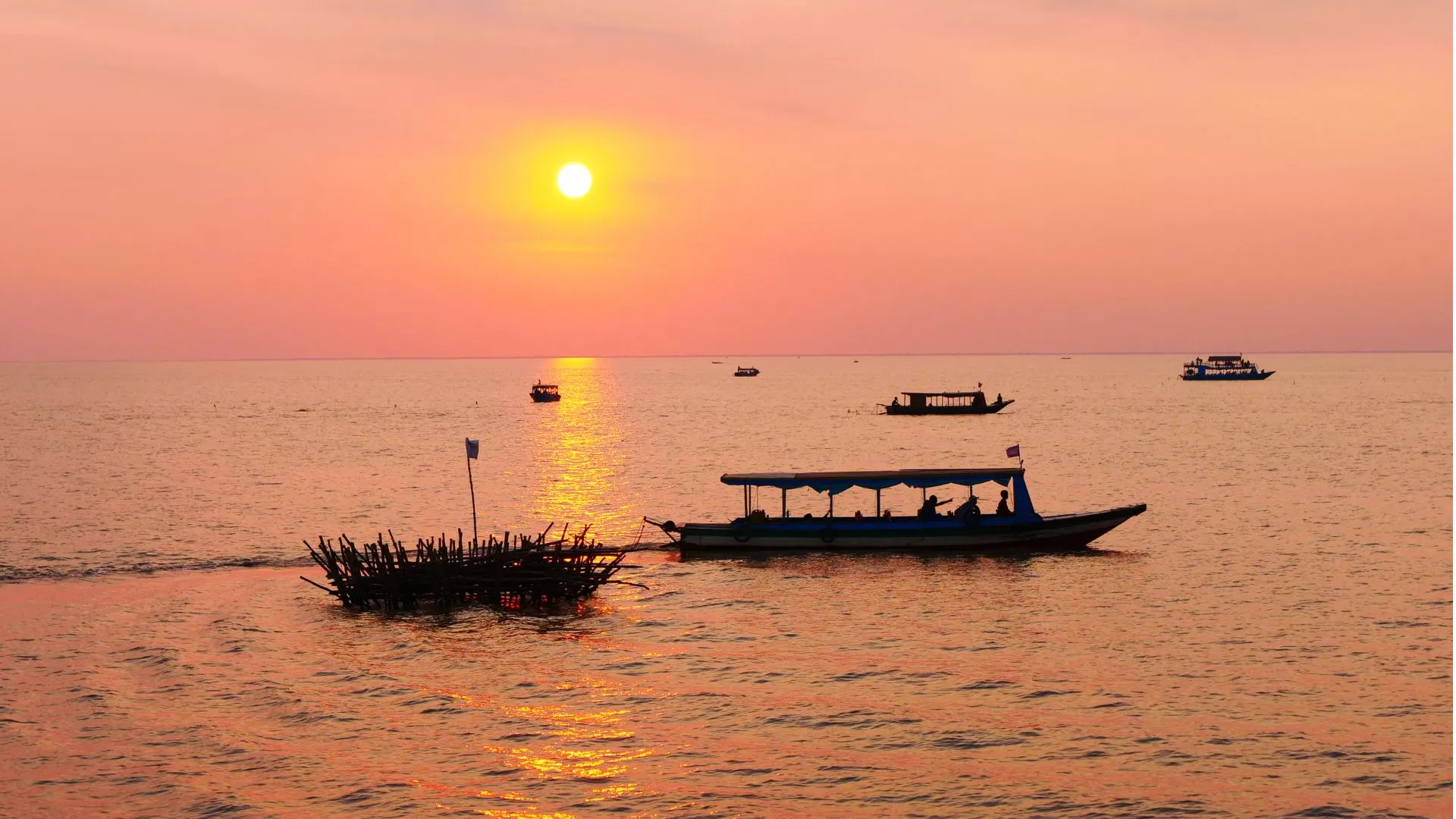 Lac Tonlé Sap avec bateaux au coucher du soleil